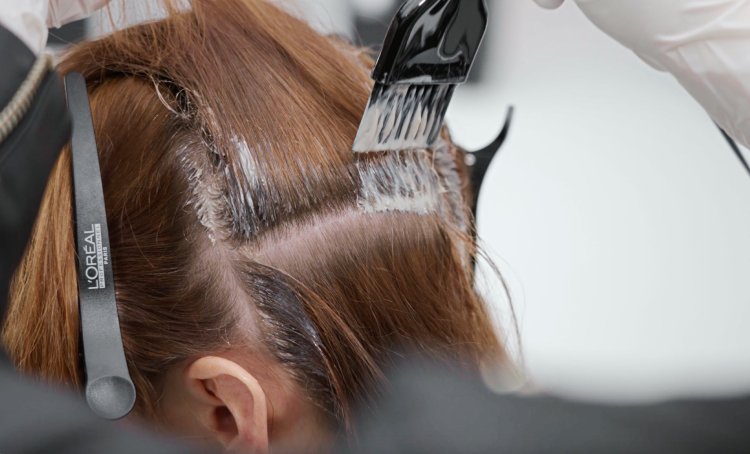 Focus on a woman at the hair salon having her hair professionally dyed with the trendy Espresso Brunette hair color.